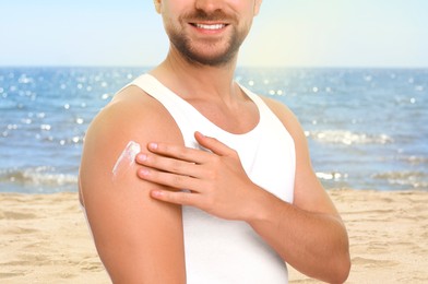 Image of Sun protection. Man applying sunblock onto skin near sea, closeup