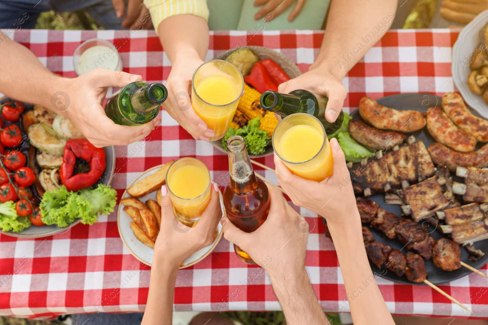 Photo of Group of friends with drinks at barbecue party outdoors, top view