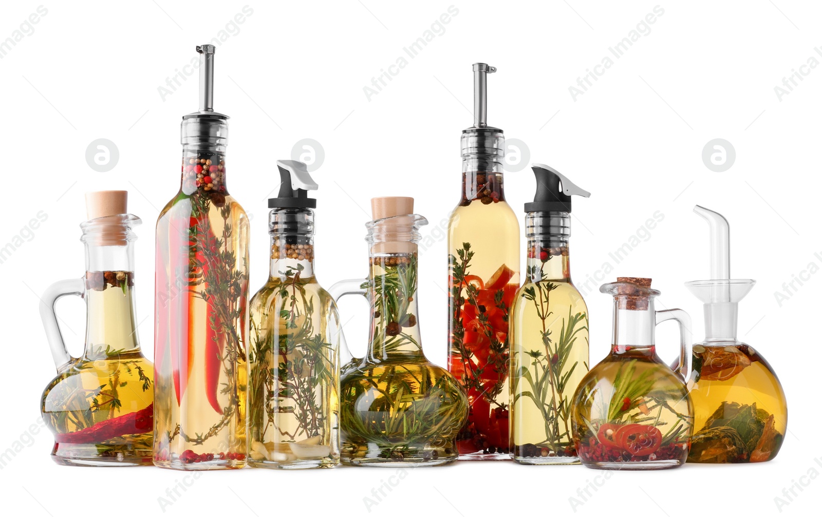 Photo of Different sorts of cooking oil with spices and herbs in bottles on white background