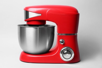 Photo of Modern red stand mixer on light grey background