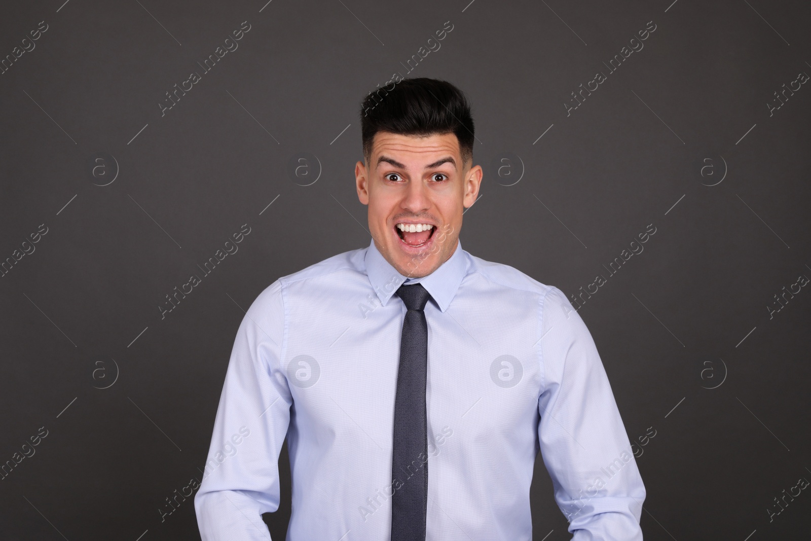 Photo of Portrait of happy businessman on dark grey background. Personality concept