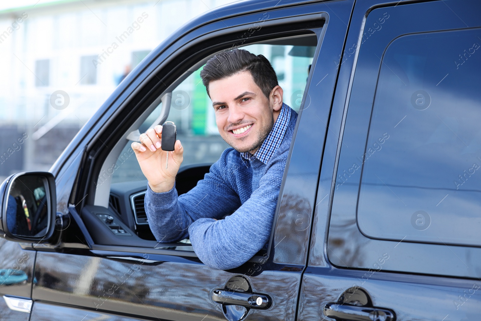 Photo of Man with key sitting in car outdoors. Buying new auto