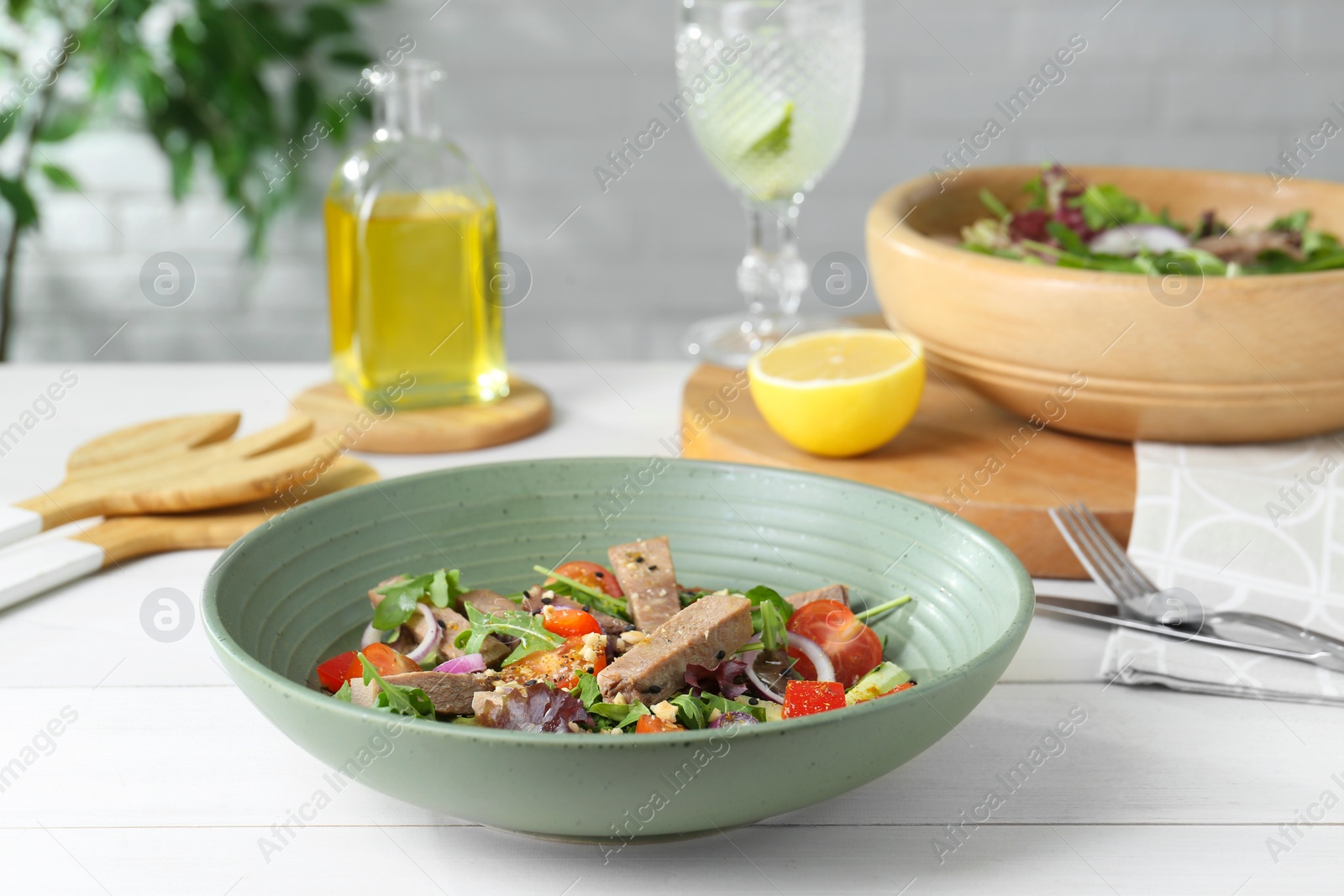 Photo of Delicious salad with beef tongue and vegetables served on white wooden table