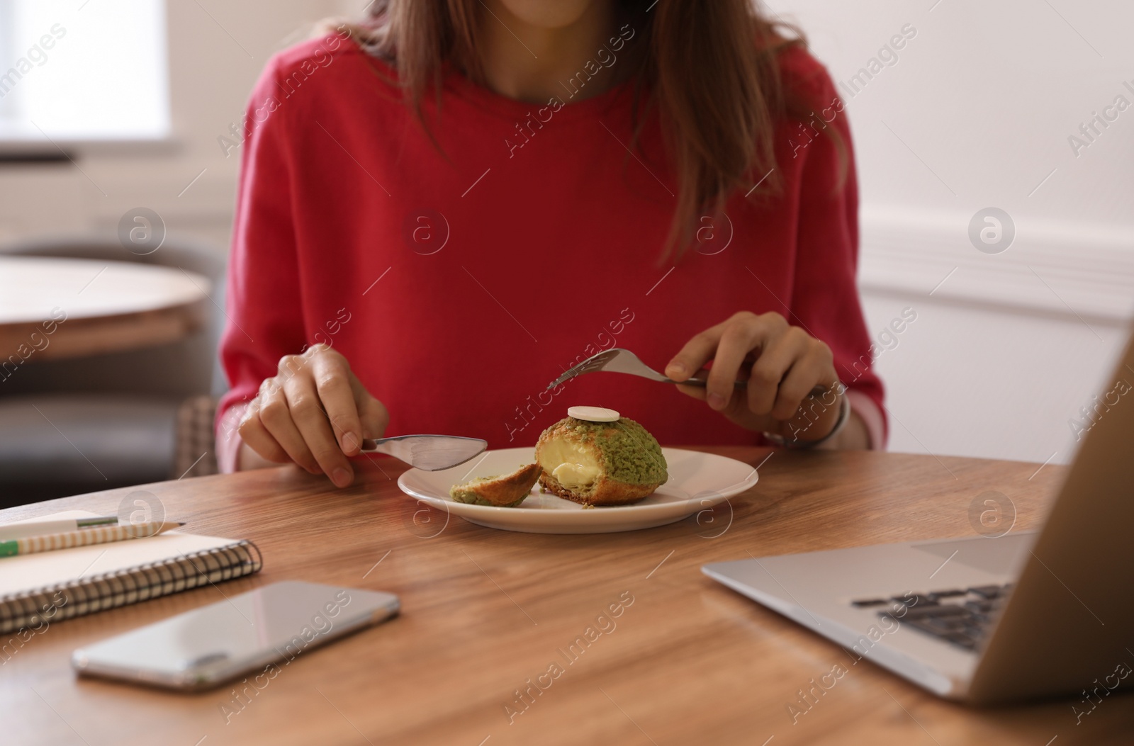 Photo of Young blogger eating dessert in cafe, closeup