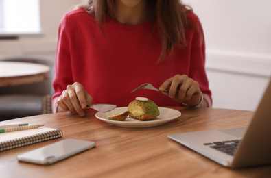 Photo of Young blogger eating dessert in cafe, closeup