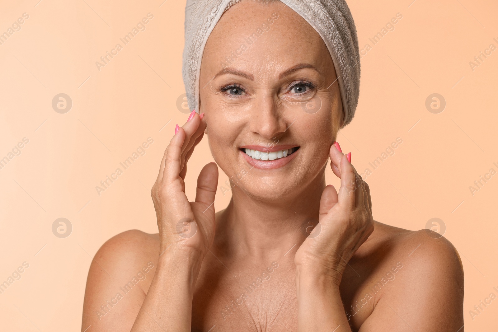 Photo of Portrait of beautiful mature woman with perfect skin on beige background