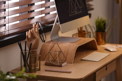 Stylish workplace with different accessories on table at window. Ideas for interior design