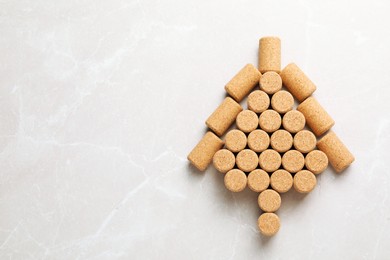 Photo of Christmas tree made of wine corks on beige table, top view. Space for text