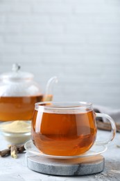 Aromatic licorice tea on light gray textured table, space for text