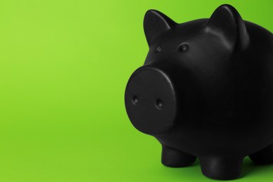 Photo of Ceramic piggy bank on green background, closeup. Space for text