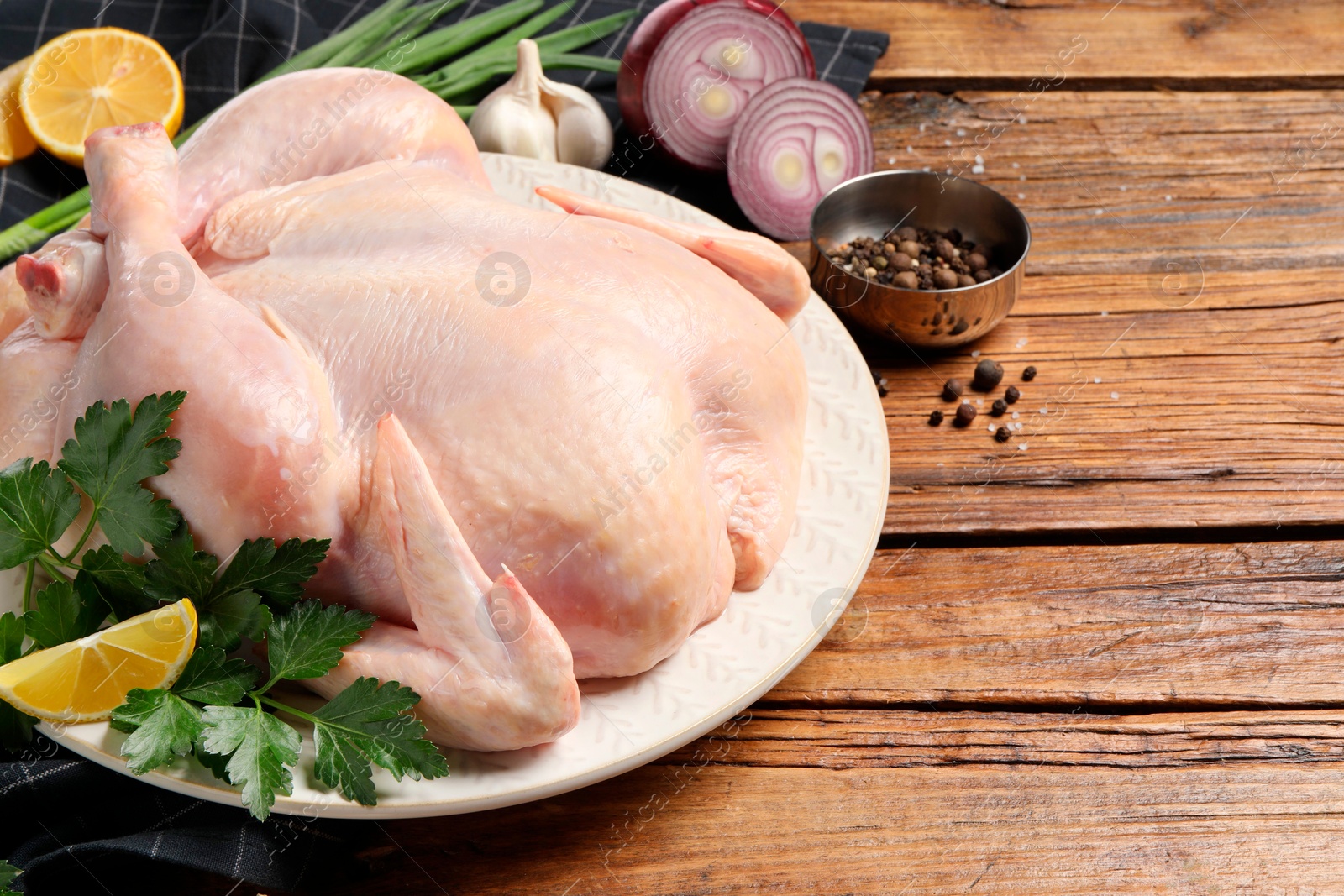 Photo of Fresh raw chicken with different products on wooden table, space for text