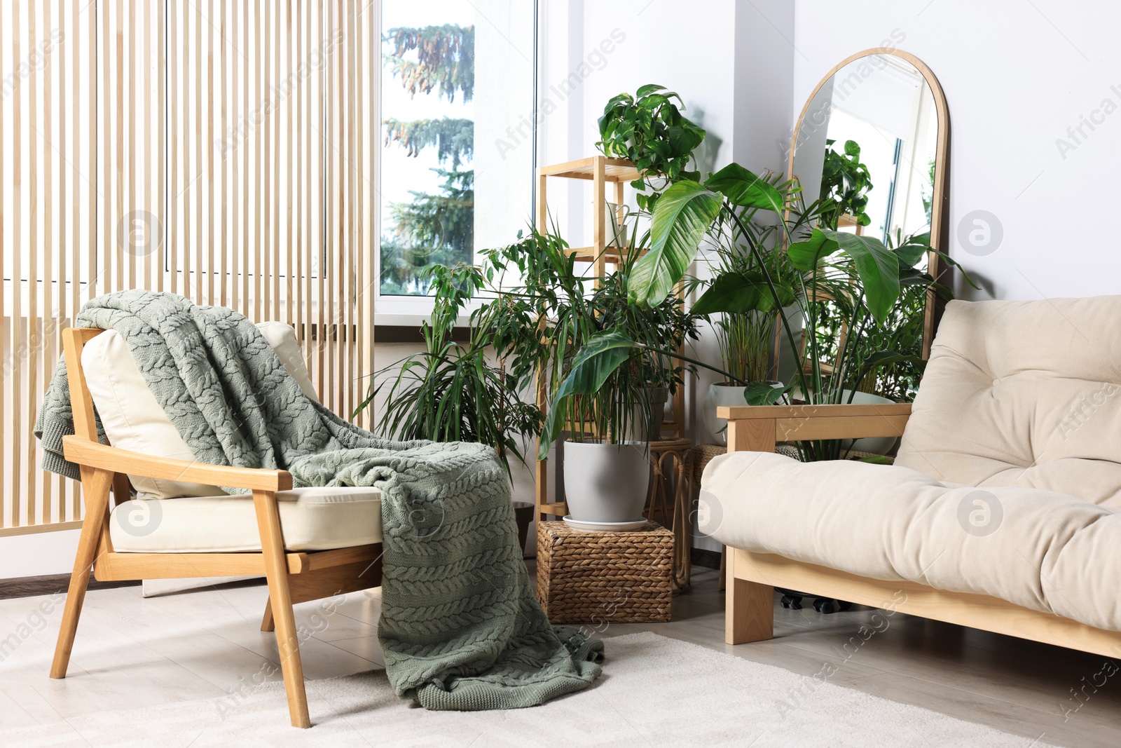 Photo of Stylish living room interior with comfortable sofa and beautiful houseplants