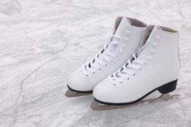 Photo of Pair of figure skates on ice, space for text