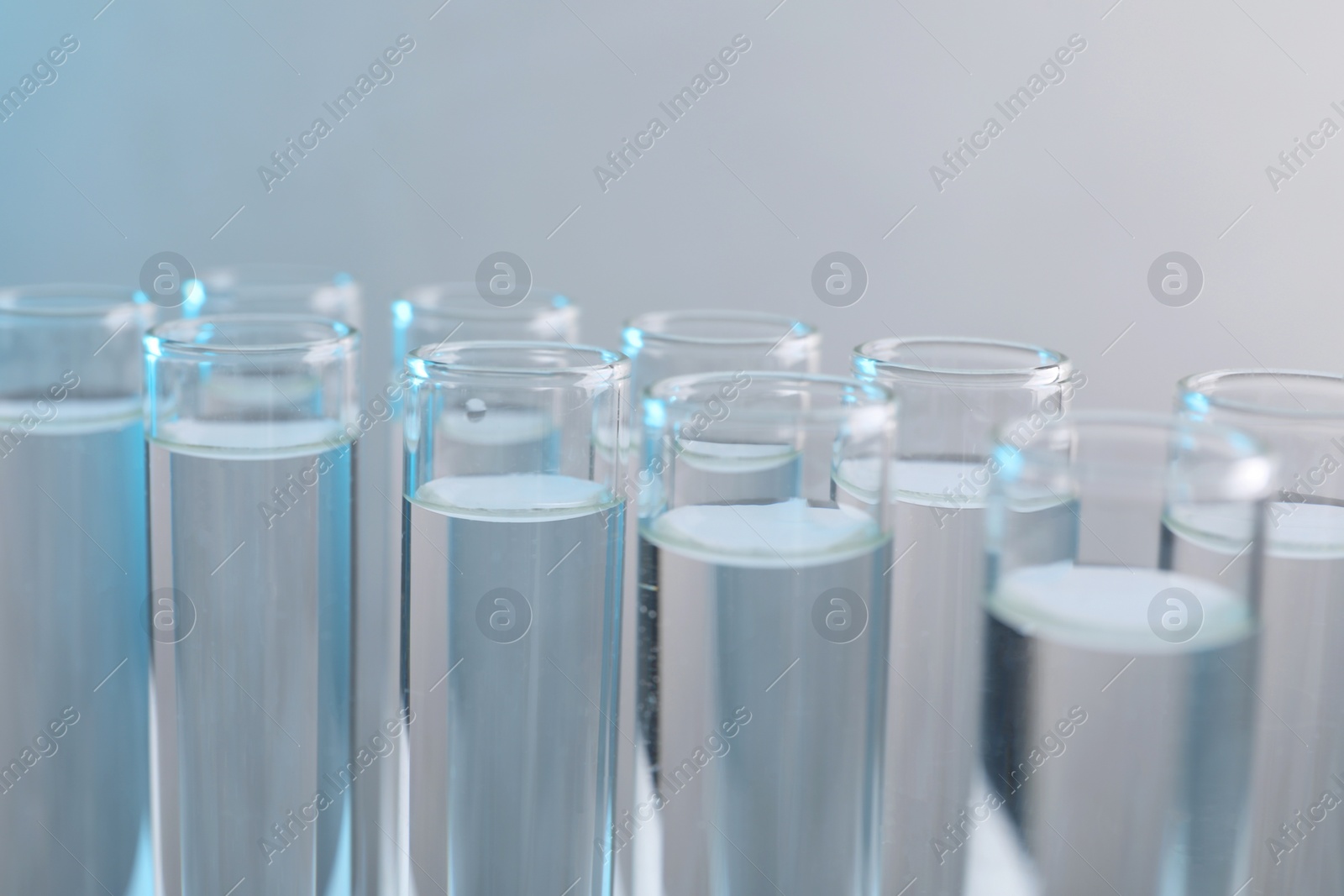 Photo of Laboratory analysis. Test tubes with liquid samples on color background, closeup