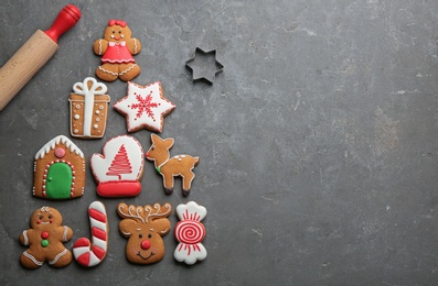 Kitchen utensils near Christmas tree shape made of delicious gingerbread cookies on grey table, flat lay. Space for text
