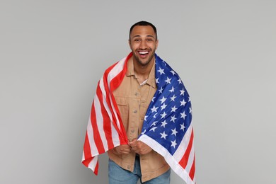 Photo of 4th of July - Independence Day of USA. Happy man with American flag on light grey background