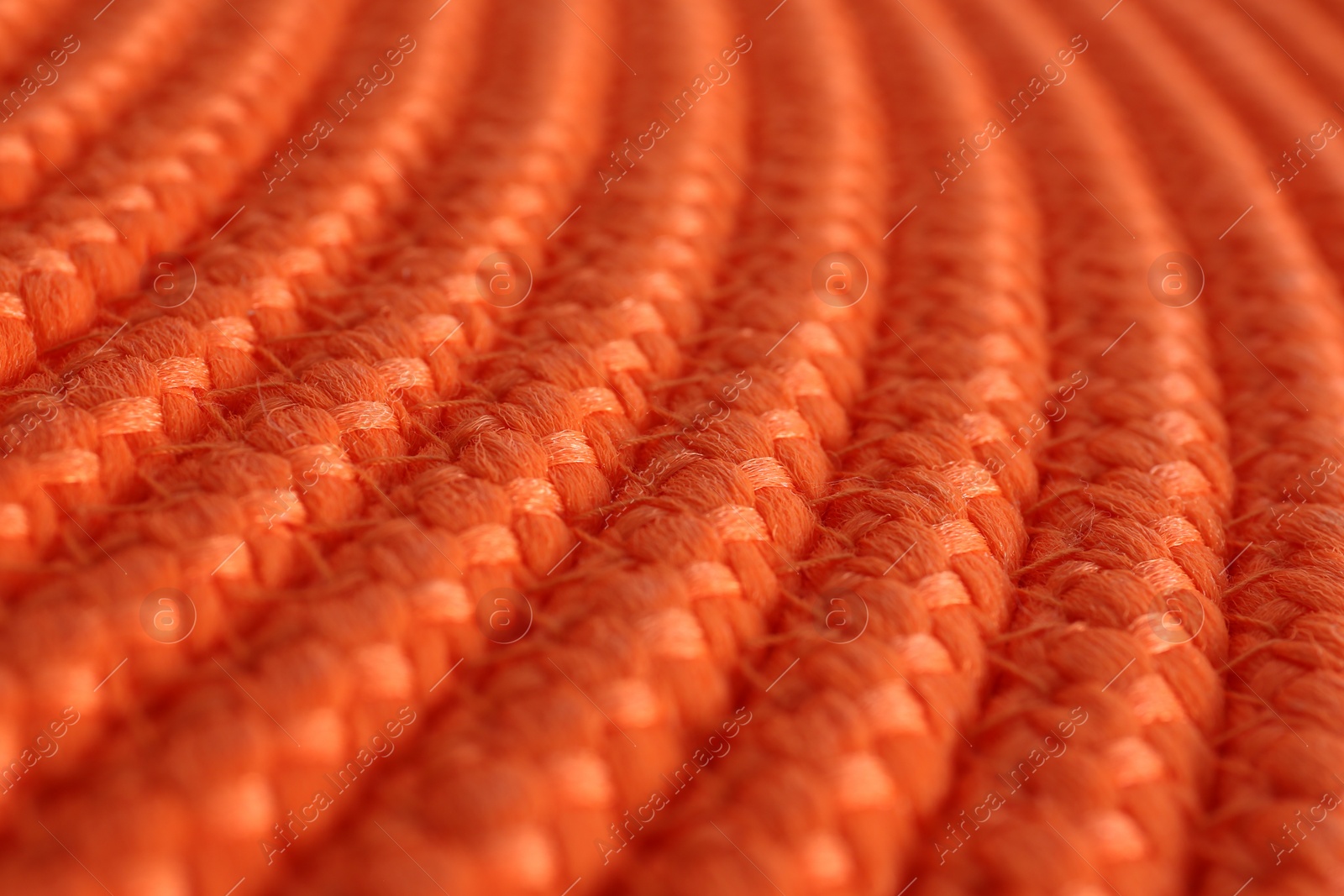 Photo of Texture of orange wicker mat as background, closeup view