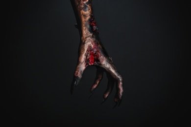 Photo of Scary monster on black background, closeup of hand. Halloween character