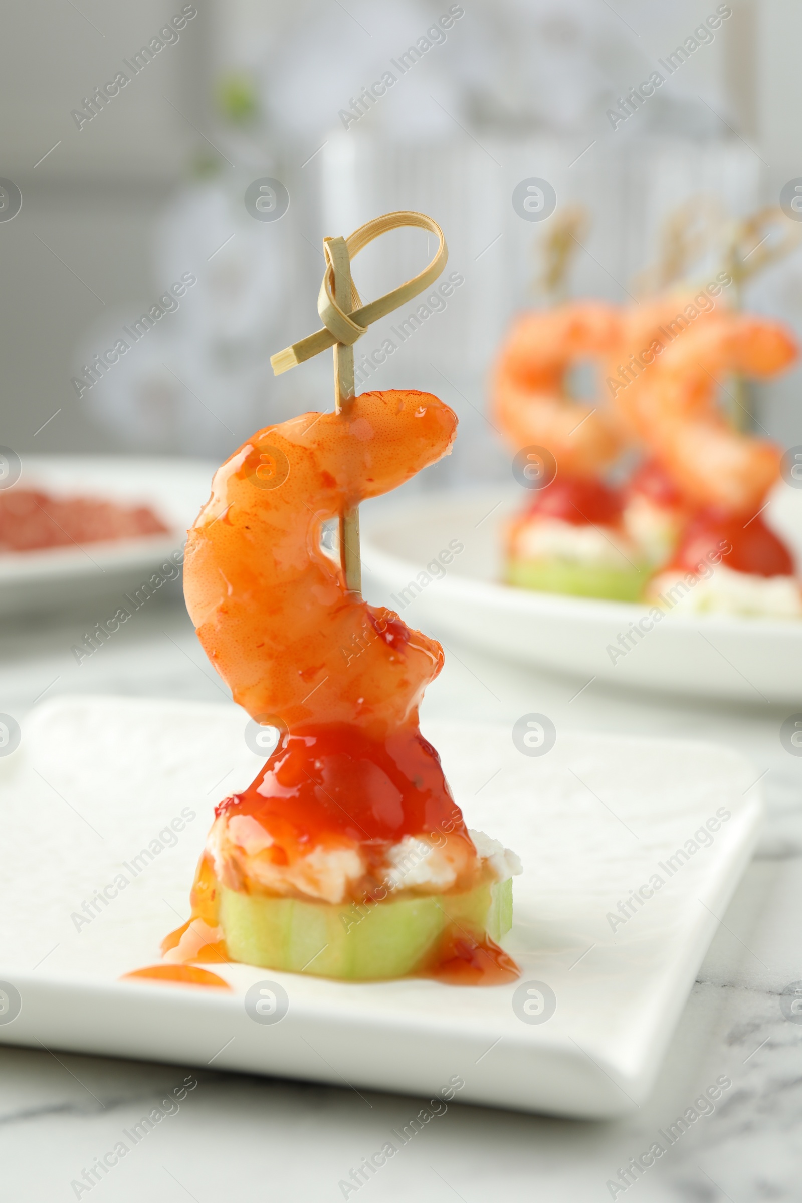 Photo of Tasty canape with shrimp, vegetables and cream cheese on white marble table, closeup