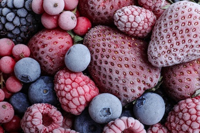 Photo of Mix of different frozen berries as background, top view