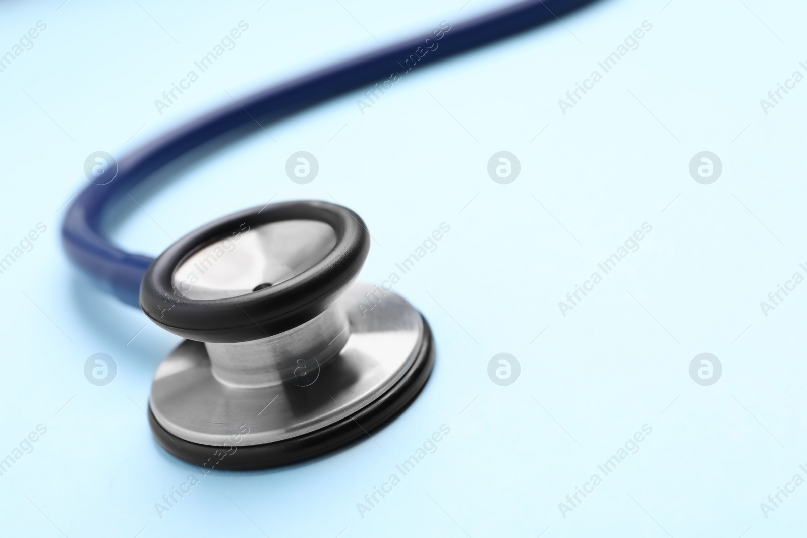 Photo of Stethoscope on light blue background, closeup. Space for text