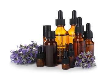 Photo of Bottles with natural lavender oil and flowers on white background