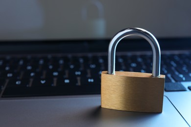 Photo of Cyber security. Metal padlock on laptop, closeup. Space for text