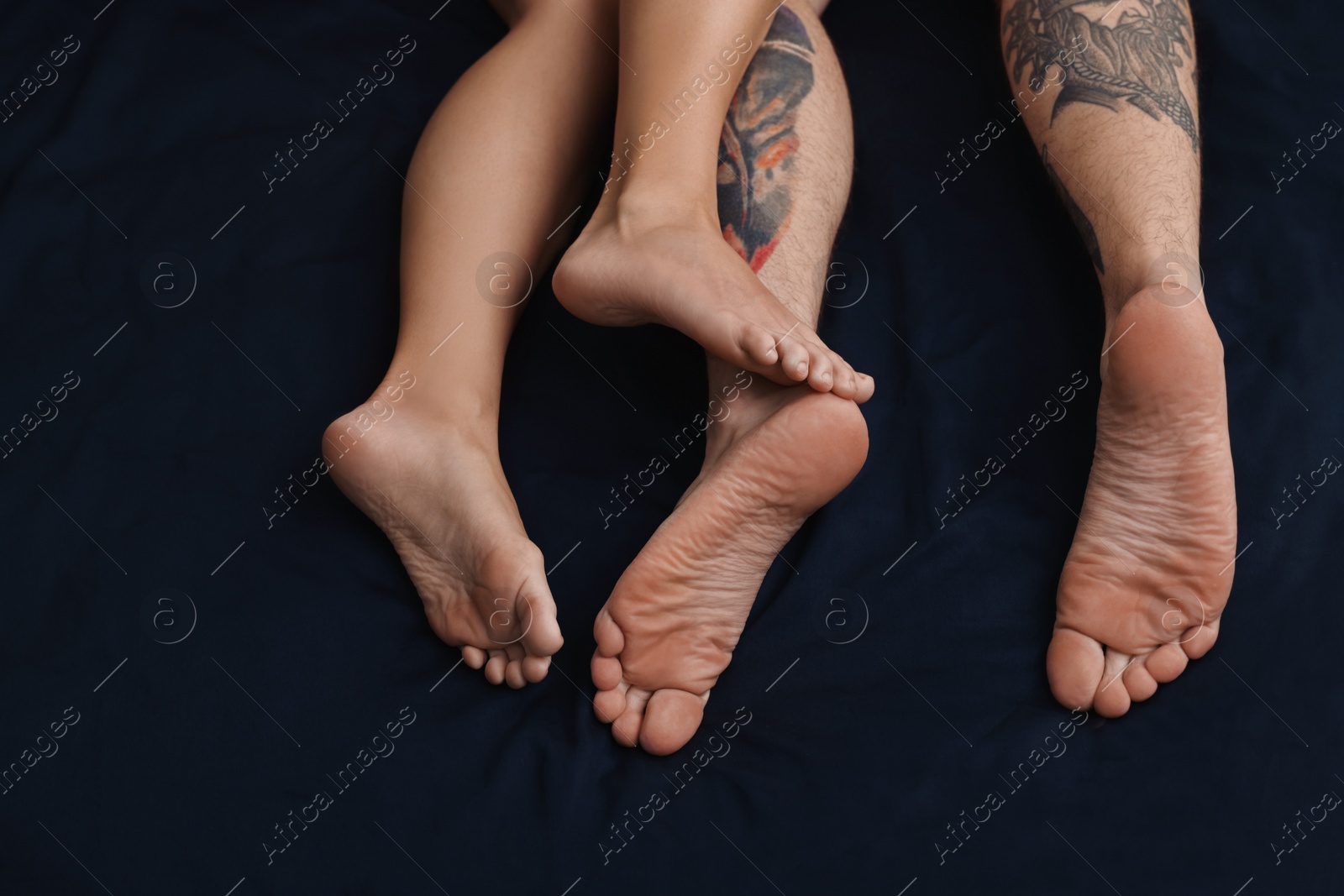 Photo of Passionate couple having sex on bed, closeup of legs