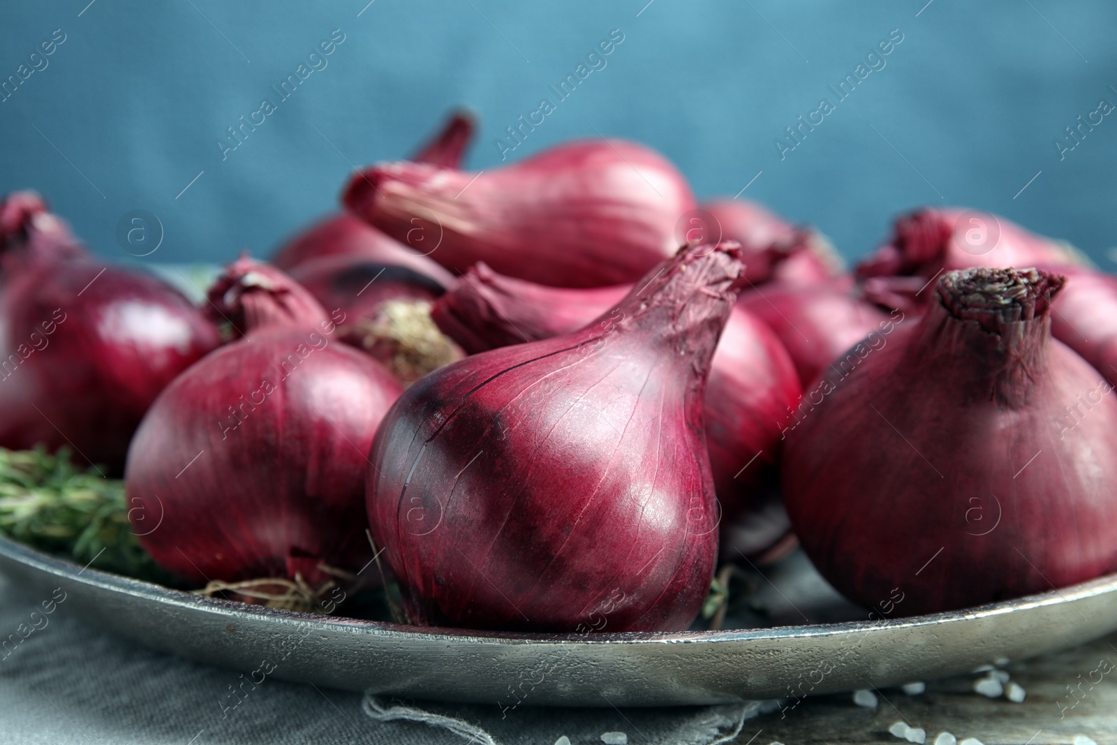 Photo of Plate with ripe red onions on table, closeup