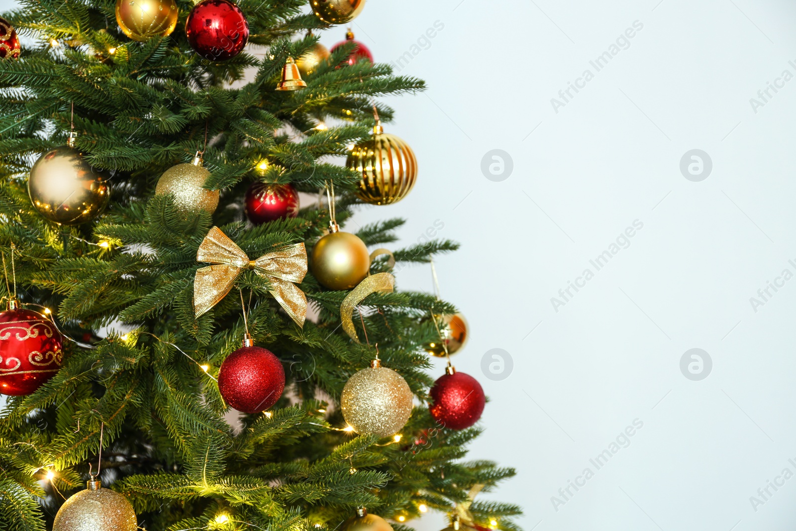 Photo of Beautiful Christmas tree with fairy lights and festive decor on white background