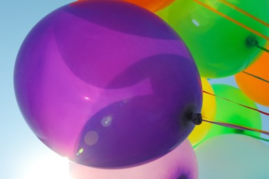 Photo of Bright colorful balloons with ribbons, closeup view