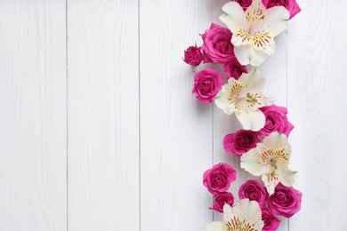 Photo of Fresh flowers on wooden background, top view with space for text