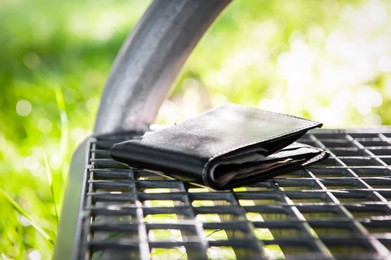 Black wallet on metal bench outdoors. Lost and found