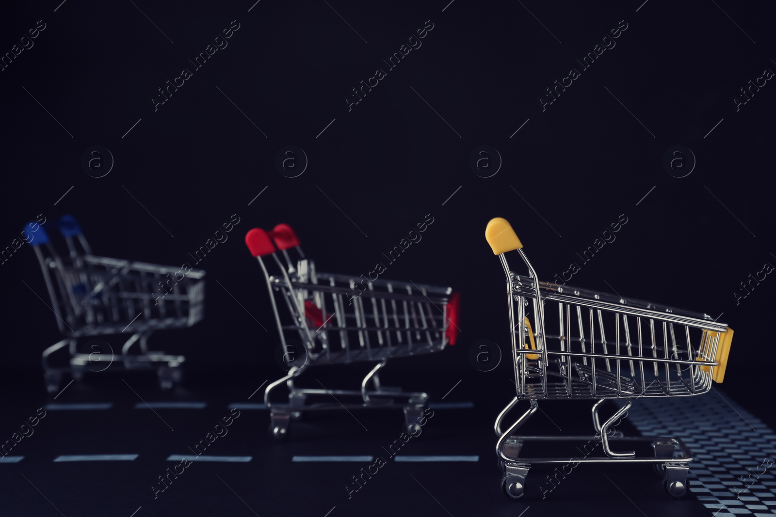 Photo of Competition concept. Shopping carts racing towards finish line