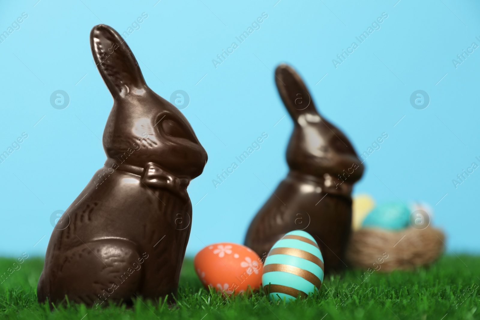 Photo of Chocolate Easter bunnies and eggs on green grass