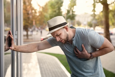 Photo of Man having heart attack on city street