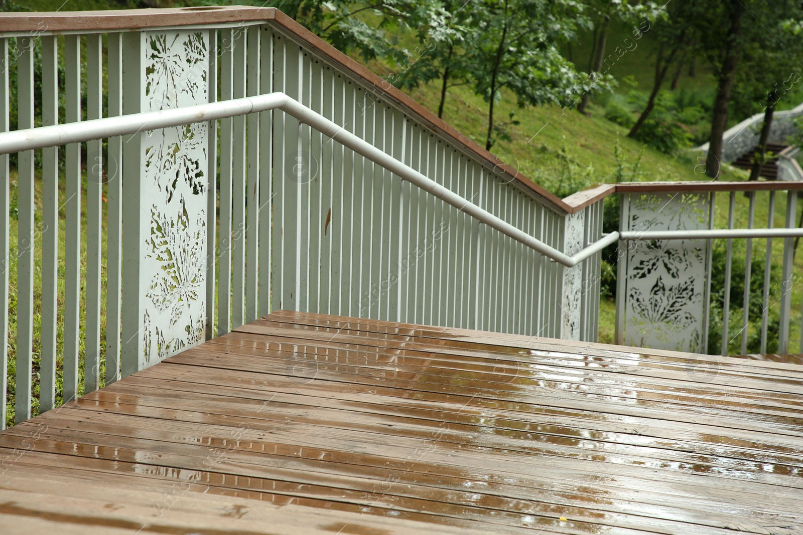 Photo of Wet wooden staircase with puddles outdoors. Rainy weather