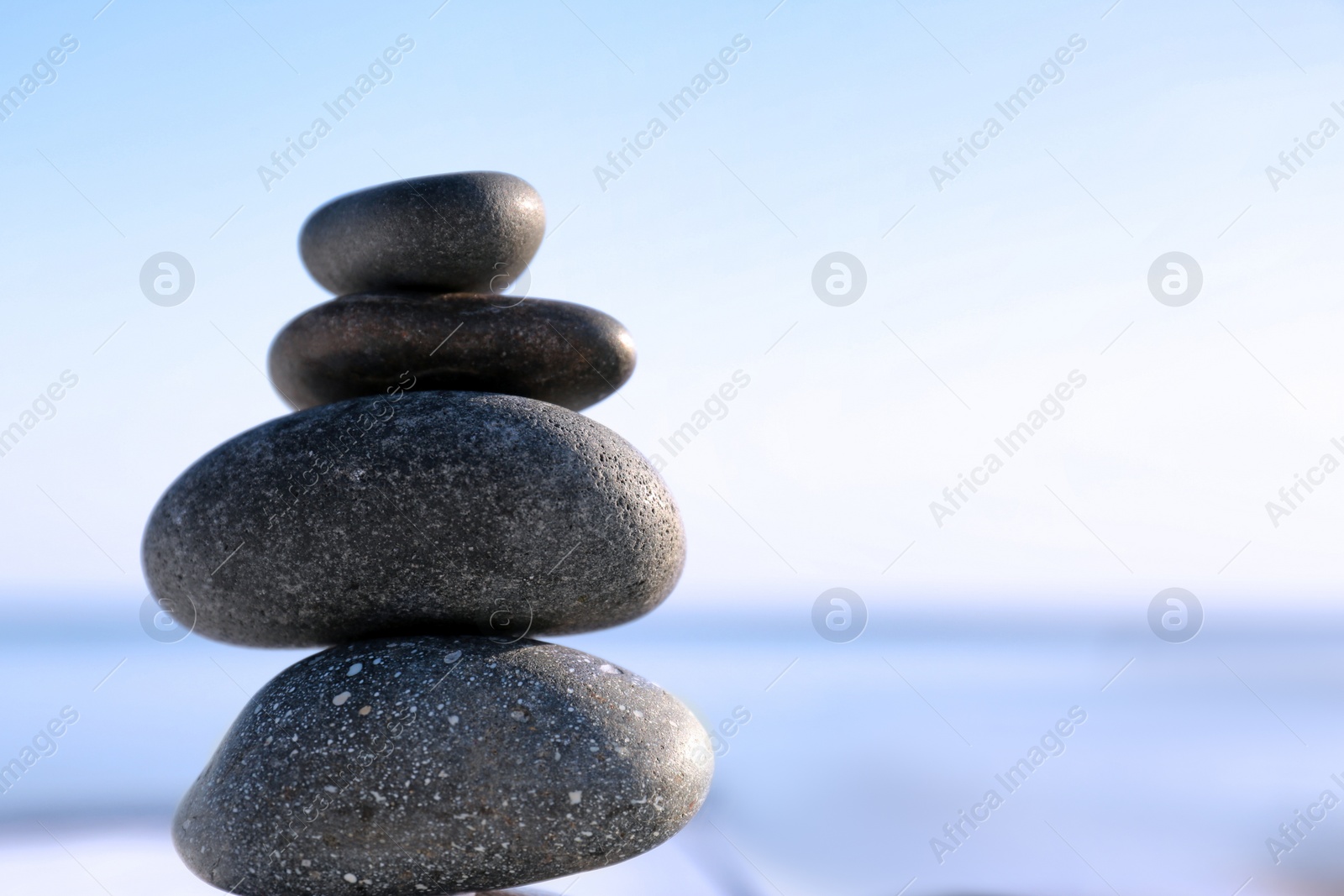 Photo of Stack of dark stones against blurred background, space for text. Zen concept