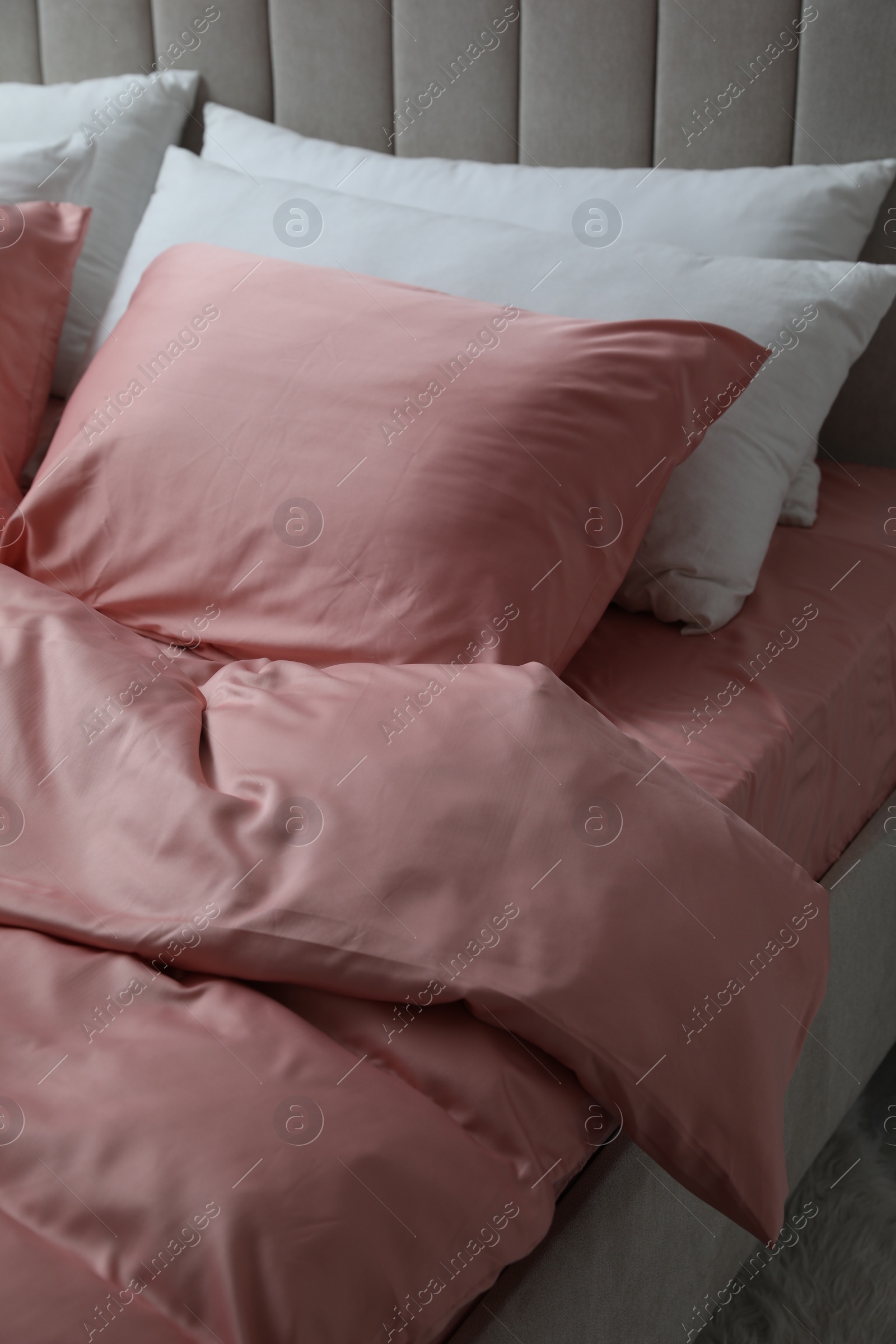 Photo of Bed with beautiful pink silk linens indoors