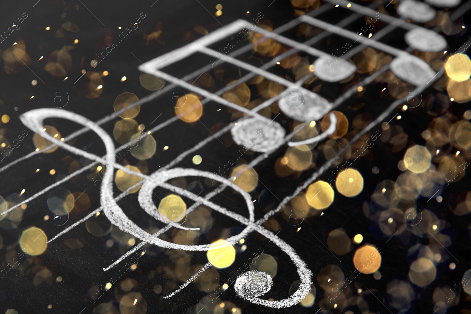 Image of Christmas and New Year music. Chalked music notes on blackboard, bokeh effect