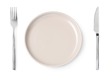 Image of Empty beige plate with fork and knife on white background, top view