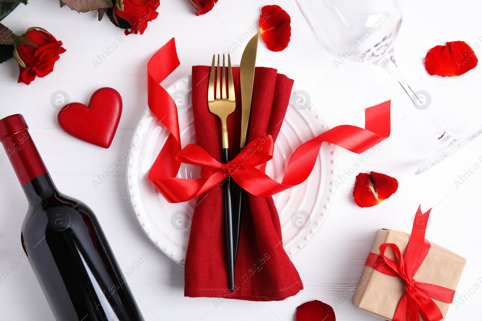 Photo of Beautiful place setting for romantic dinner on white wooden table, flat lay. Valentine's day celebration