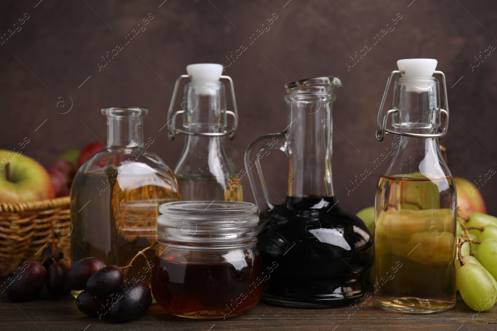 Photo of Different types of vinegar and fresh fruits on wooden table