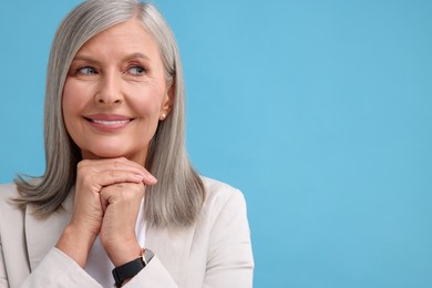 Photo of Portrait of beautiful middle aged woman on light blue background, space for text