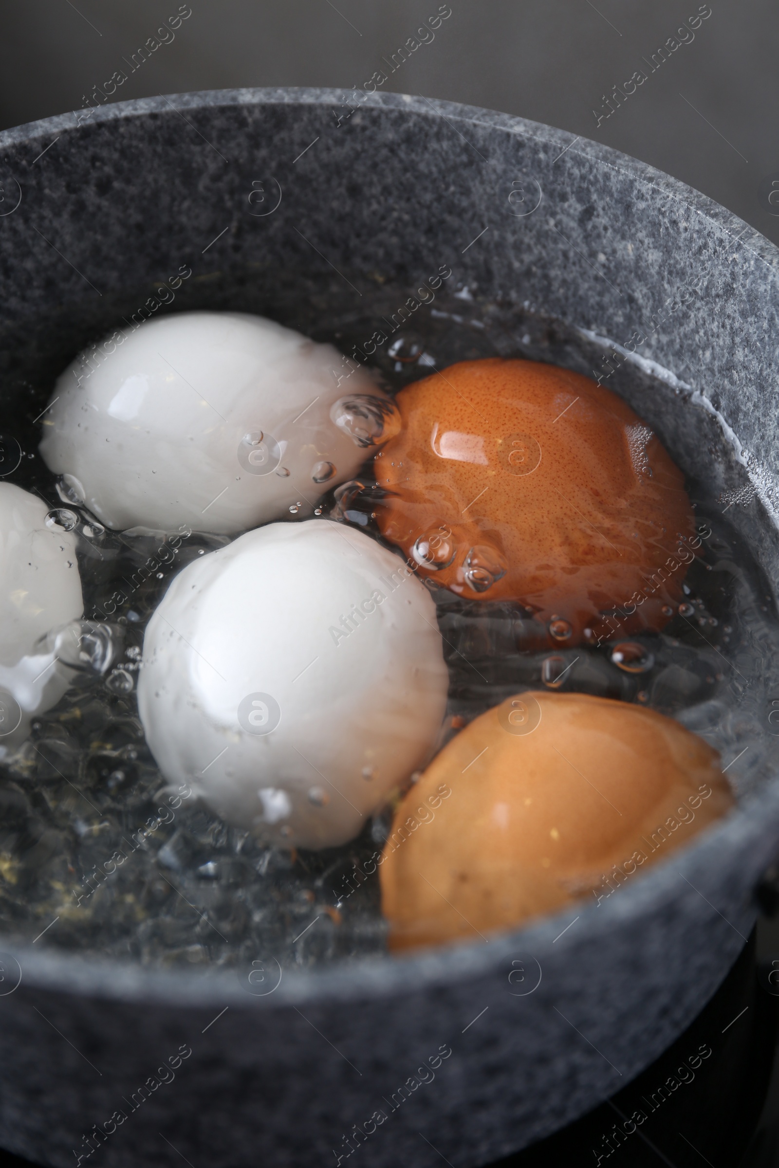 Photo of Chicken eggs boiling in saucepan, closeup view