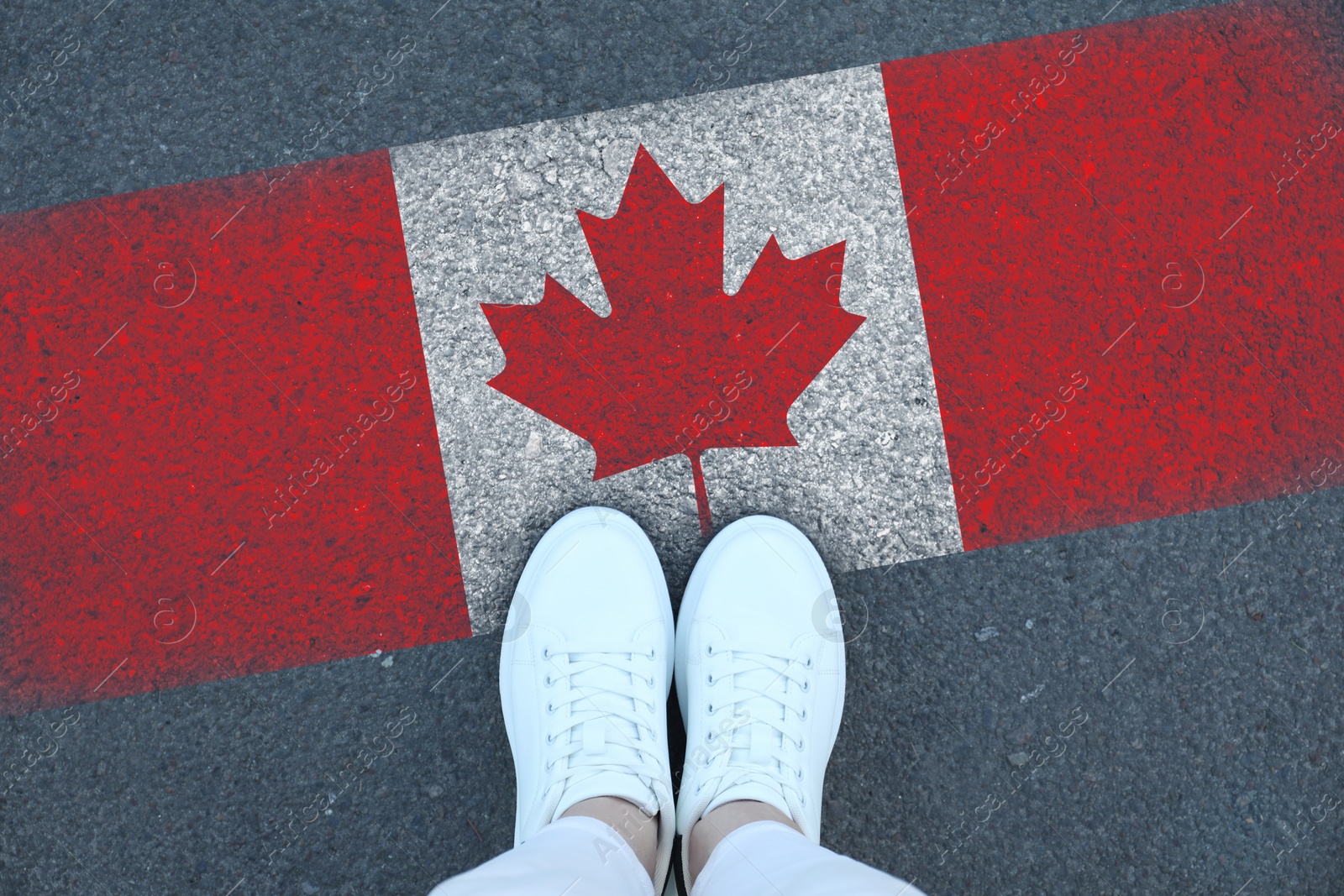 Image of Immigration. Woman standing on asphalt near flag of Canada, top view