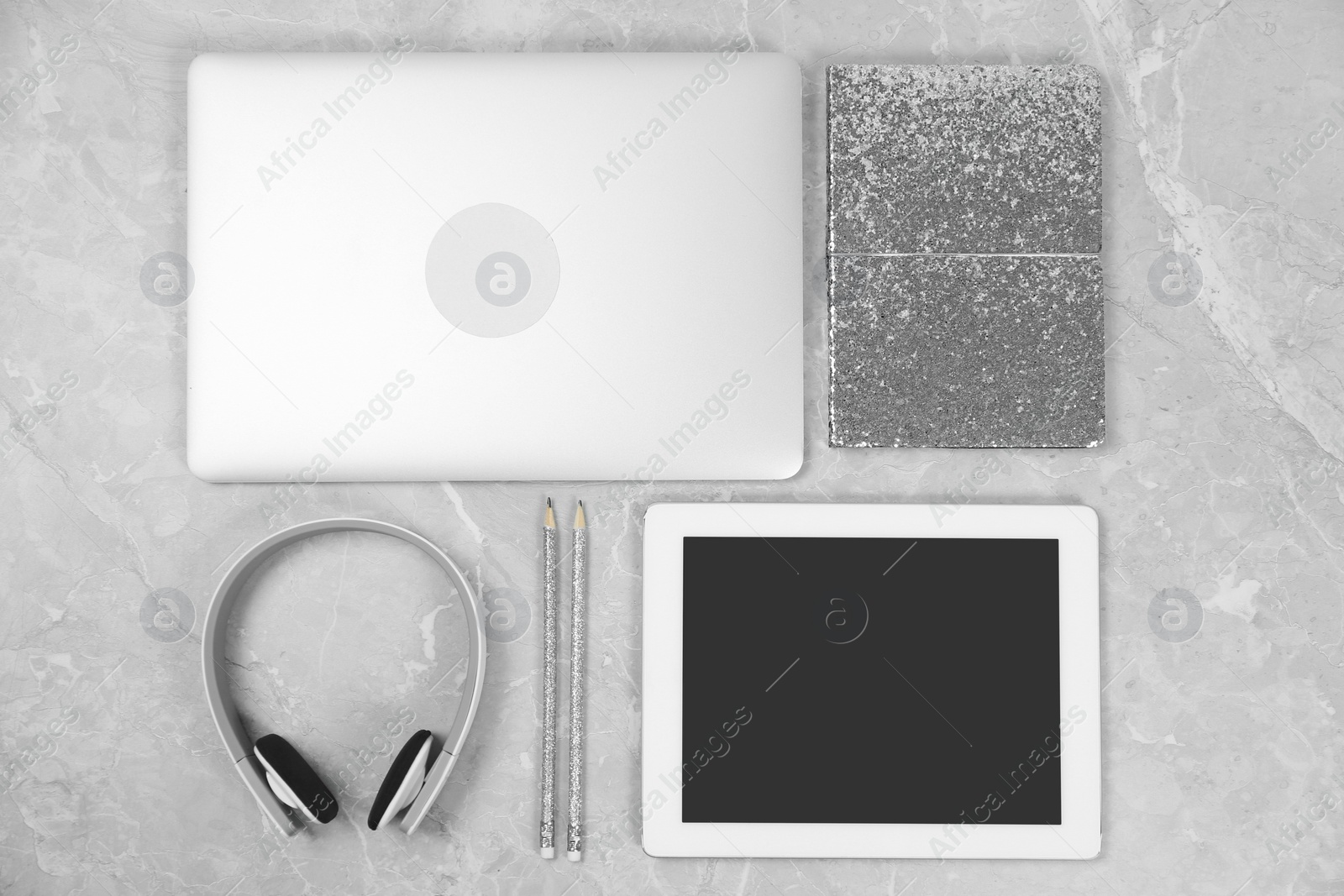 Photo of Flat lay composition with laptop, tablet and notebook on grey marble table, space for text. Designer's workplace