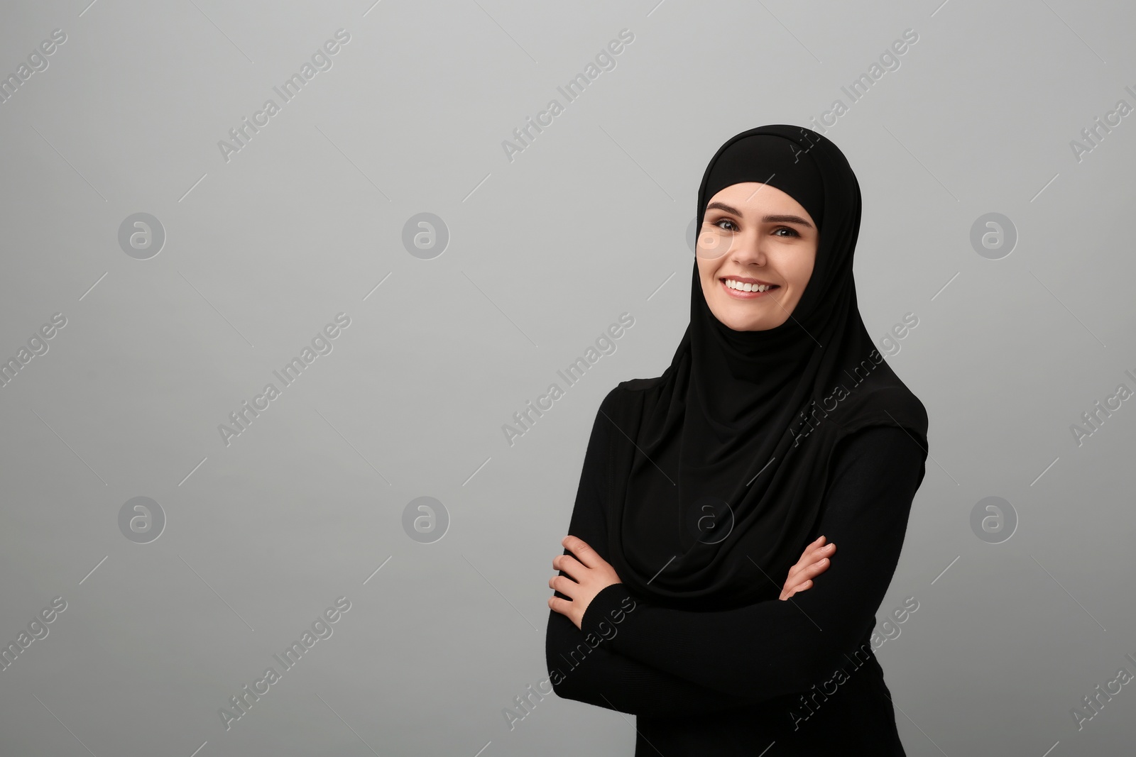 Photo of Portrait of Muslim woman in hijab on light gray background, space for text