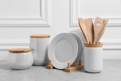 Photo of Set of different kitchenware on light gray table near white wall