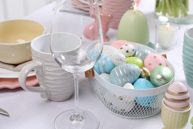 Photo of Festive table setting with painted eggs. Easter celebration